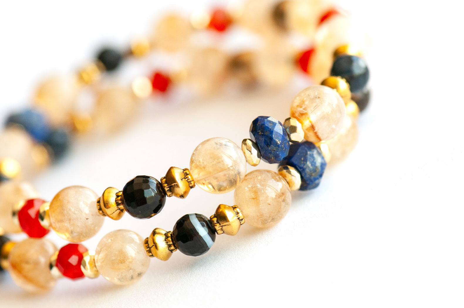 Supporting bracelets from Symbolist Lynx featuring Lapis Lazuli, Carnelian, and gold-plated Hematite