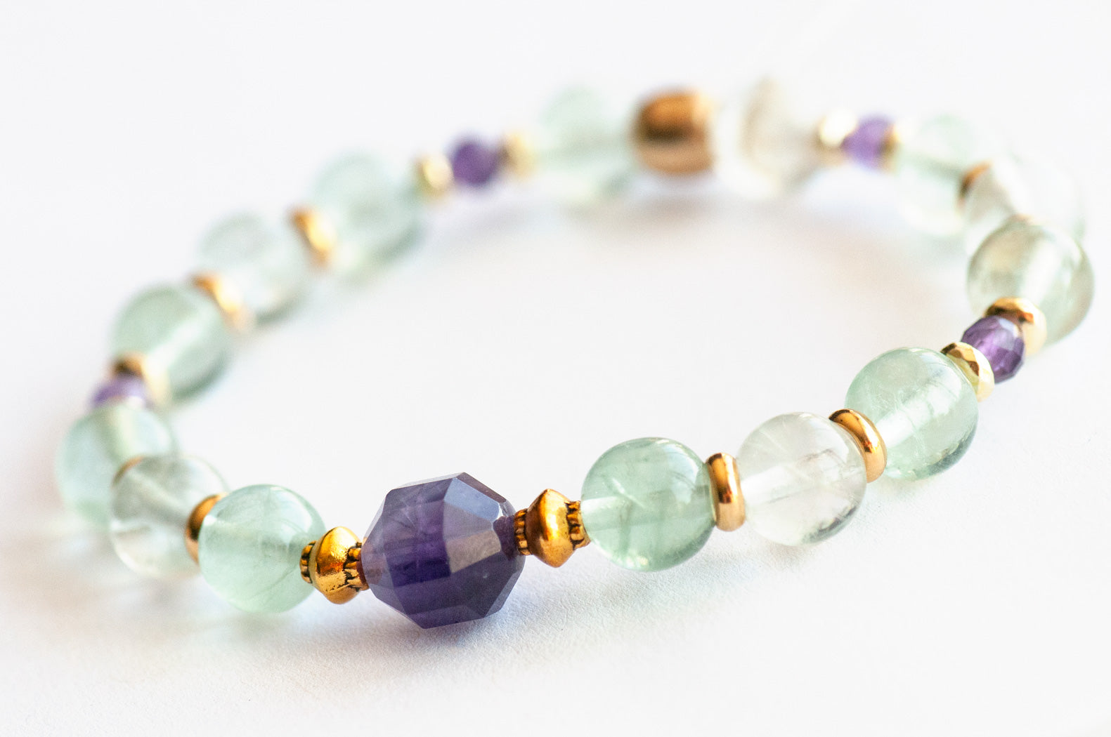 Close-up of Symbolist Lynx focal bracelet with pale green Fluorite and faceted Amethyst beads