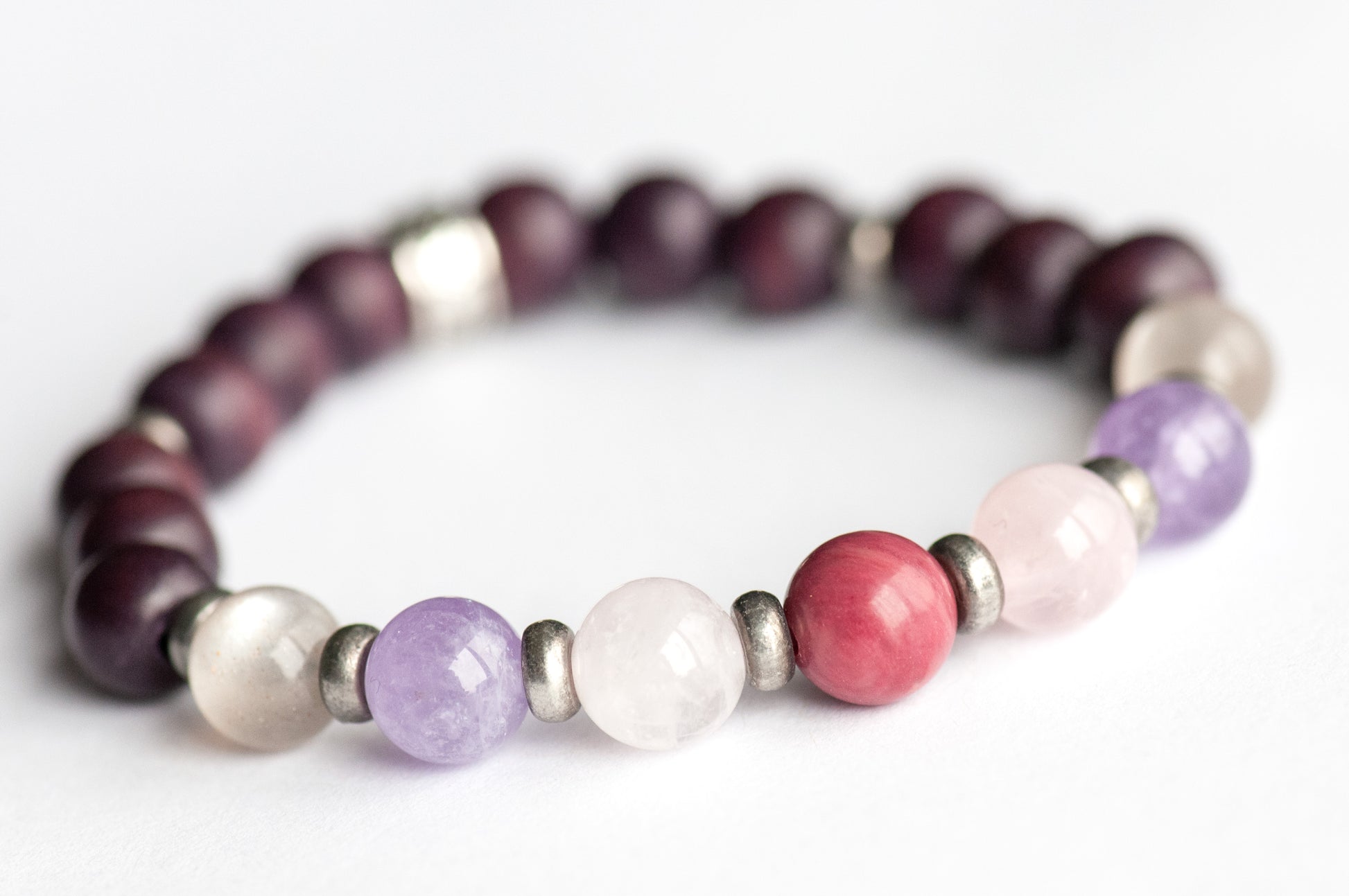 Fierce Grace bracelet featuring Rhodonite, Rose Quartz, Amethyst, and Moonstone gemstones on white background