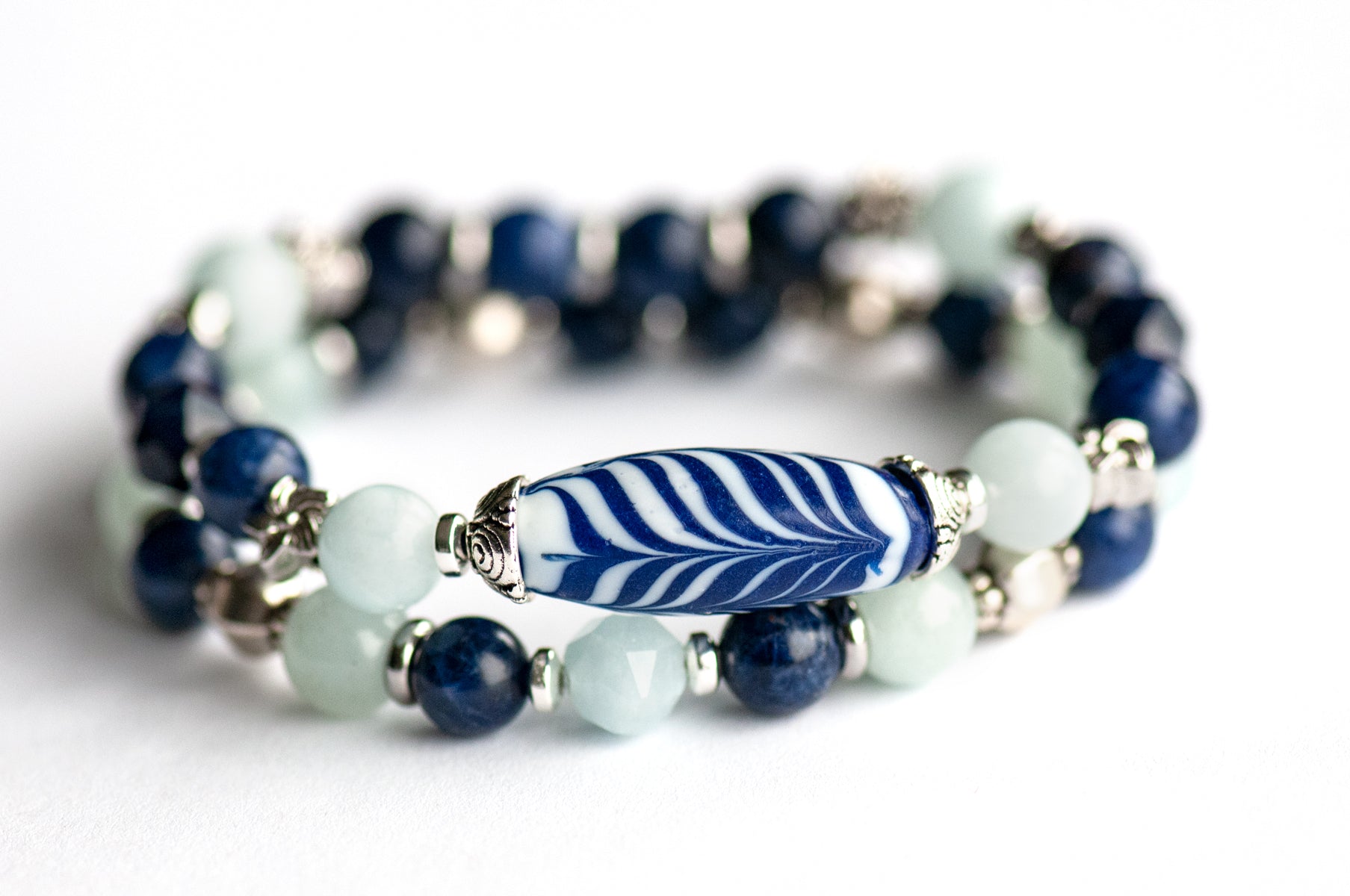 Larkspur Bracelet Set: Aquamarine, Sodalite & a handmade glass feather bead celebrate July's birth flower — open-hearted, light, and full of summer grace.