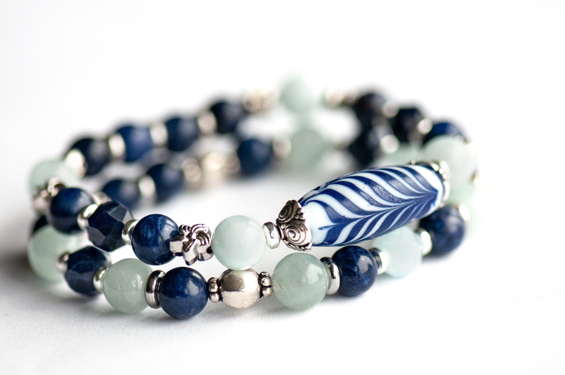 Larkspur Bracelet Set: Aquamarine, Sodalite & a handmade glass feather bead celebrate July's birth flower — open-hearted, light, and full of summer grace.
