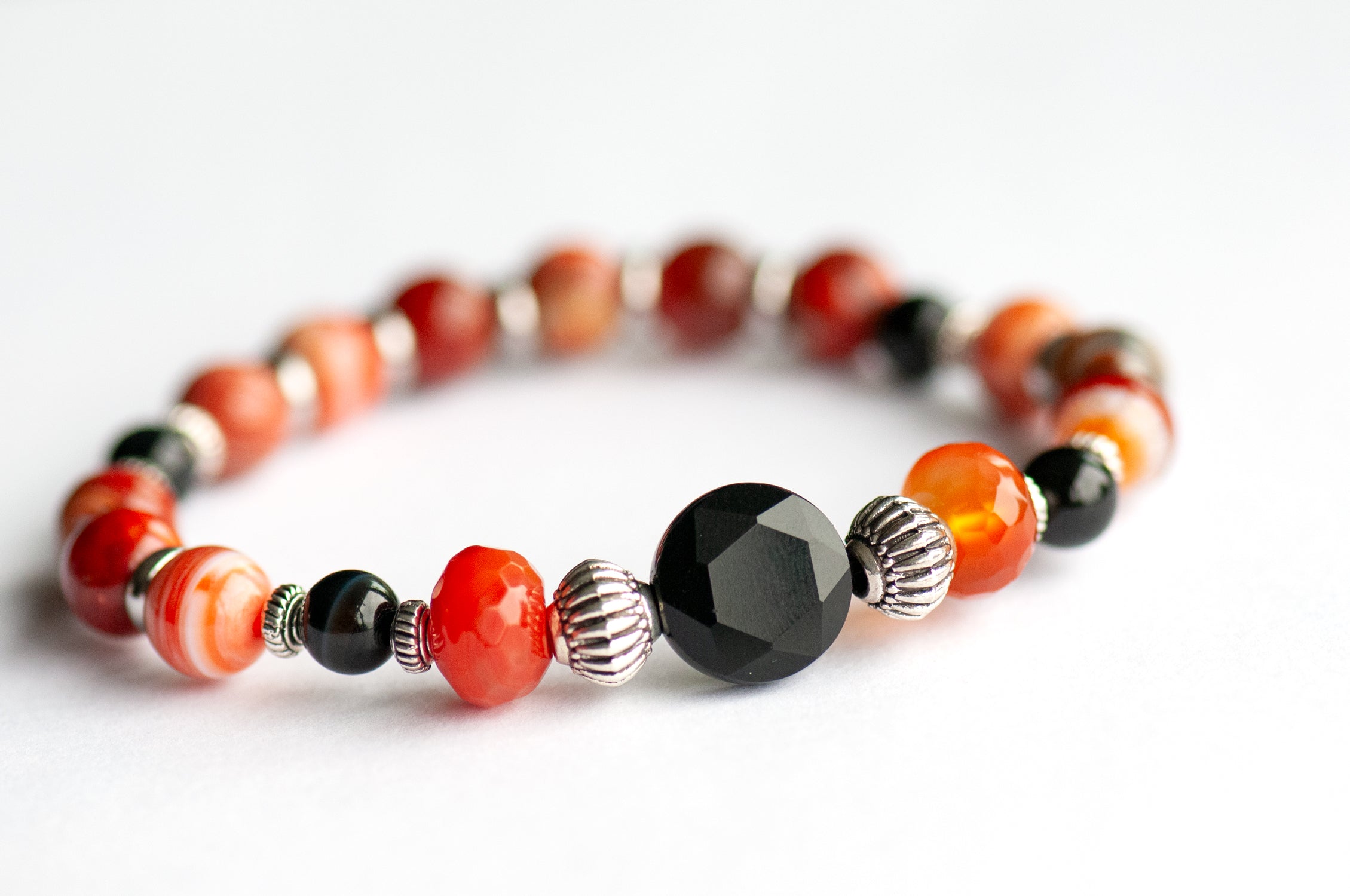 Poppy focal bracelet: Black Onyx, Red Agate & Flower Poppy Jasper celebrate August's birth flower — bold resilience in deep burnt reds and grounding black.