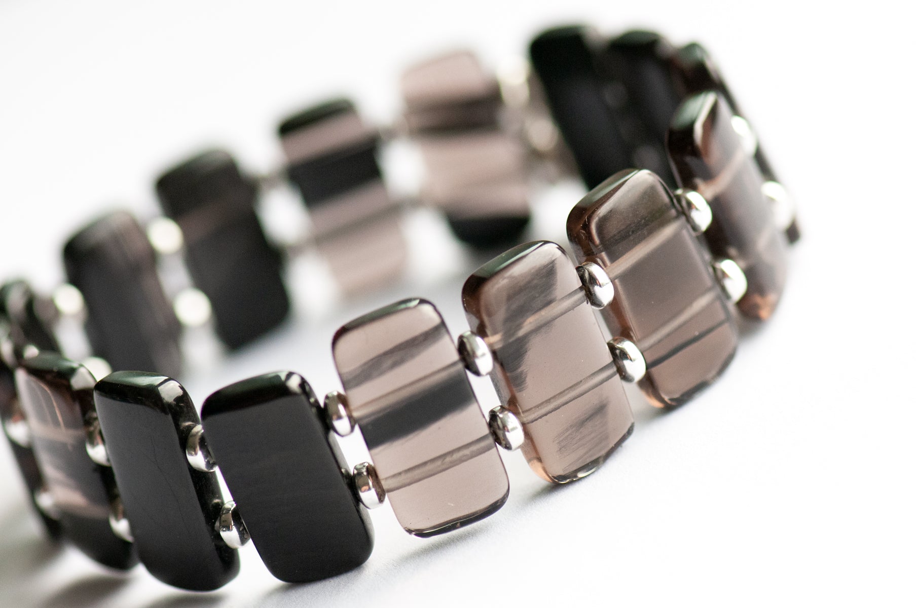 Ice Obsidian cuff bracelet — sleek black glass-like stone that reveals hidden streaks in the light. Handmade, ethically sourced, crafted in New Brunswick.
