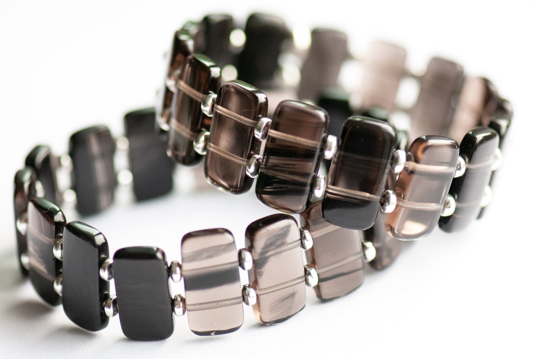 Ice Obsidian cuff bracelet — sleek black glass-like stone that reveals hidden streaks in the light. Handmade, ethically sourced, crafted in New Brunswick.