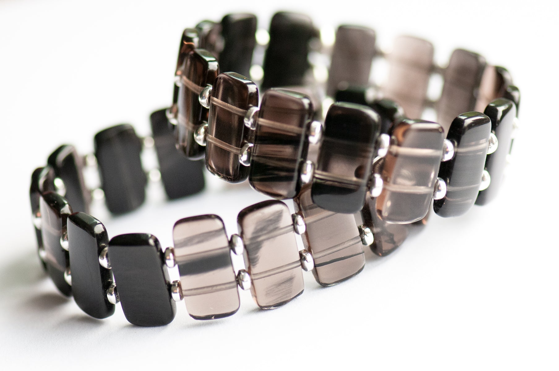 Ice Obsidian cuff bracelet — sleek black glass-like stone that reveals hidden streaks in the light. Handmade, ethically sourced, crafted in New Brunswick.