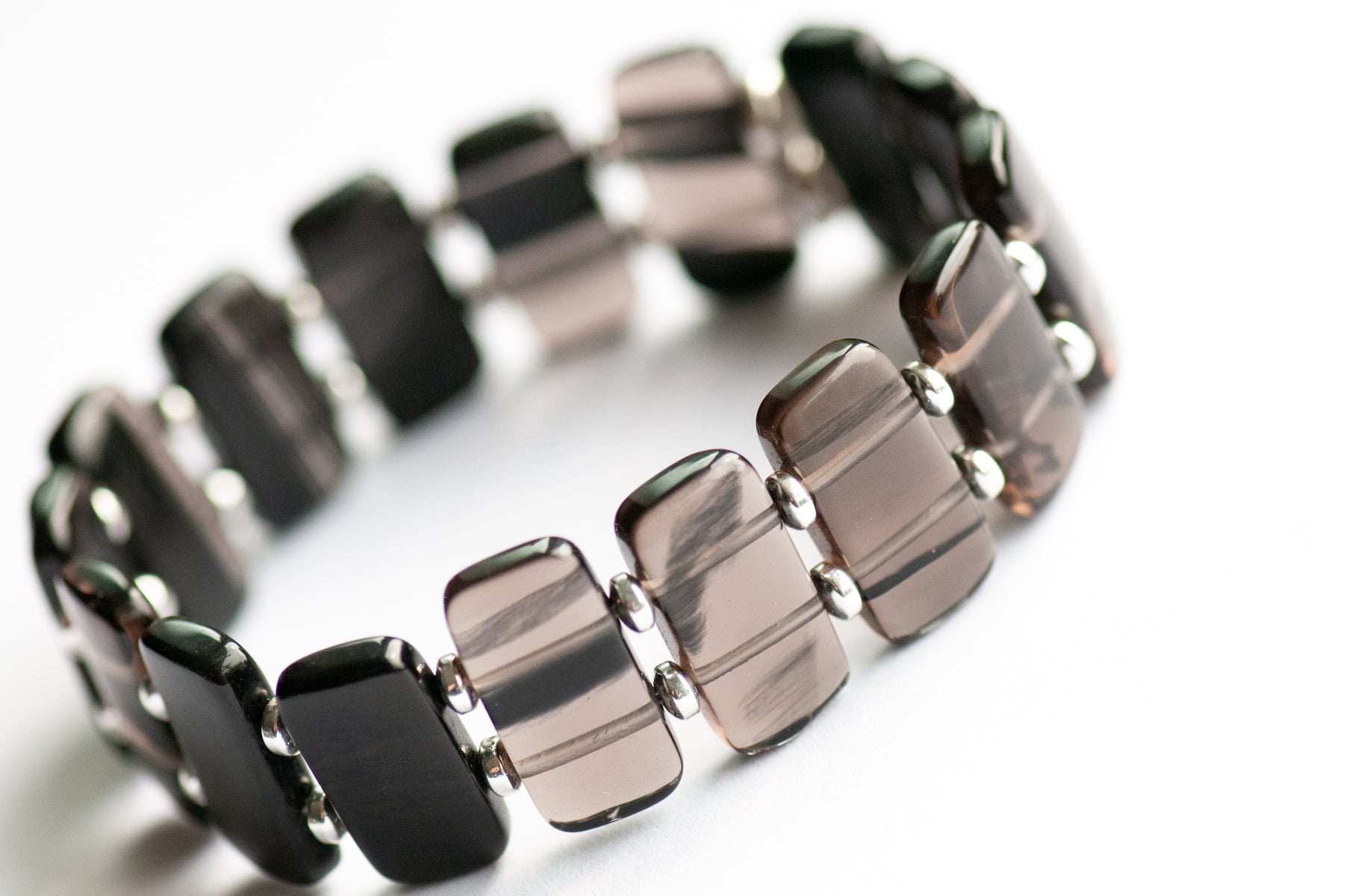 Ice Obsidian cuff bracelet — sleek black glass-like stone that reveals hidden streaks in the light. Handmade, ethically sourced, crafted in New Brunswick.