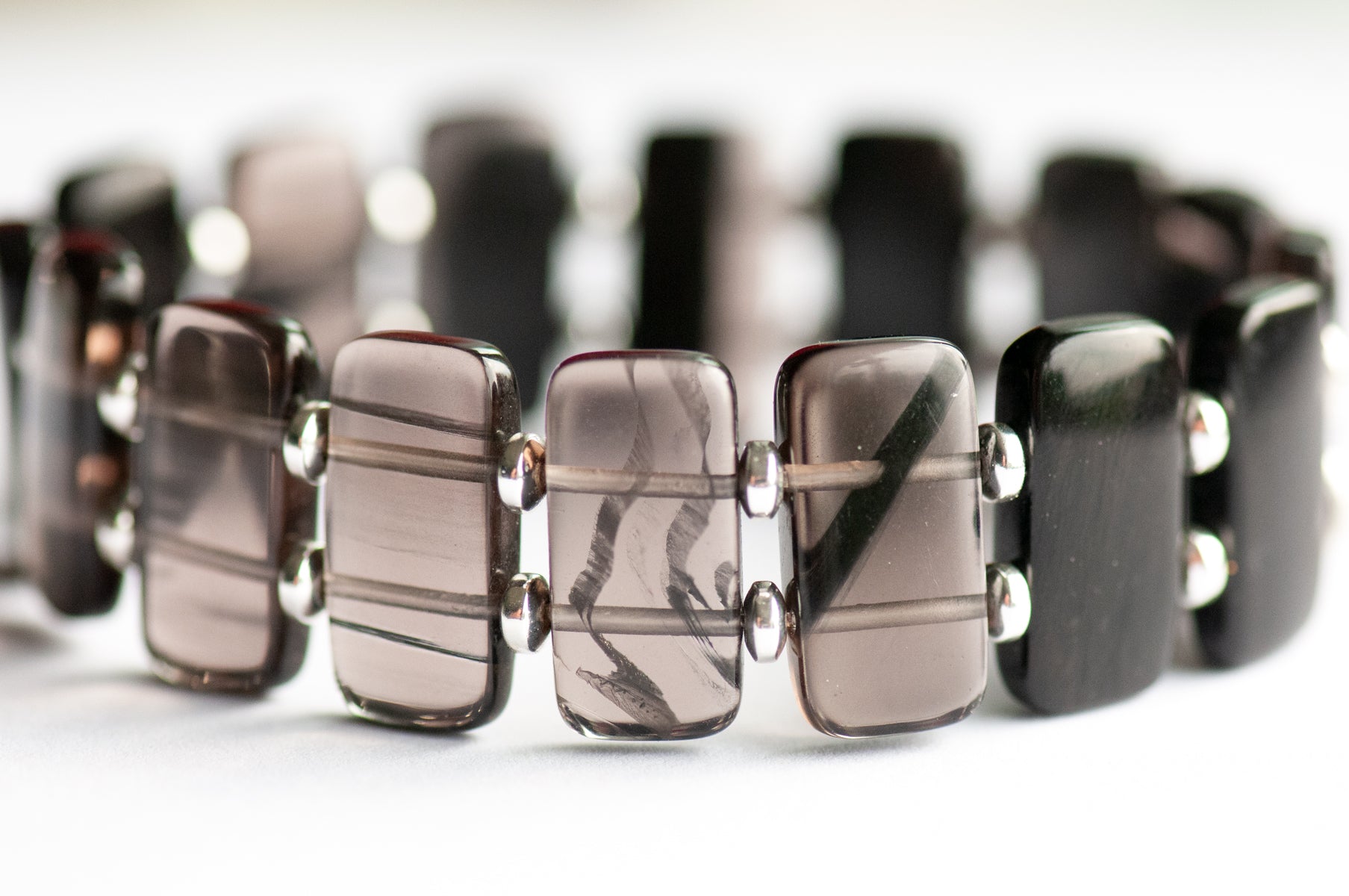 Ice Obsidian cuff bracelet — sleek black glass-like stone that reveals hidden streaks in the light. Handmade, ethically sourced, crafted in New Brunswick.