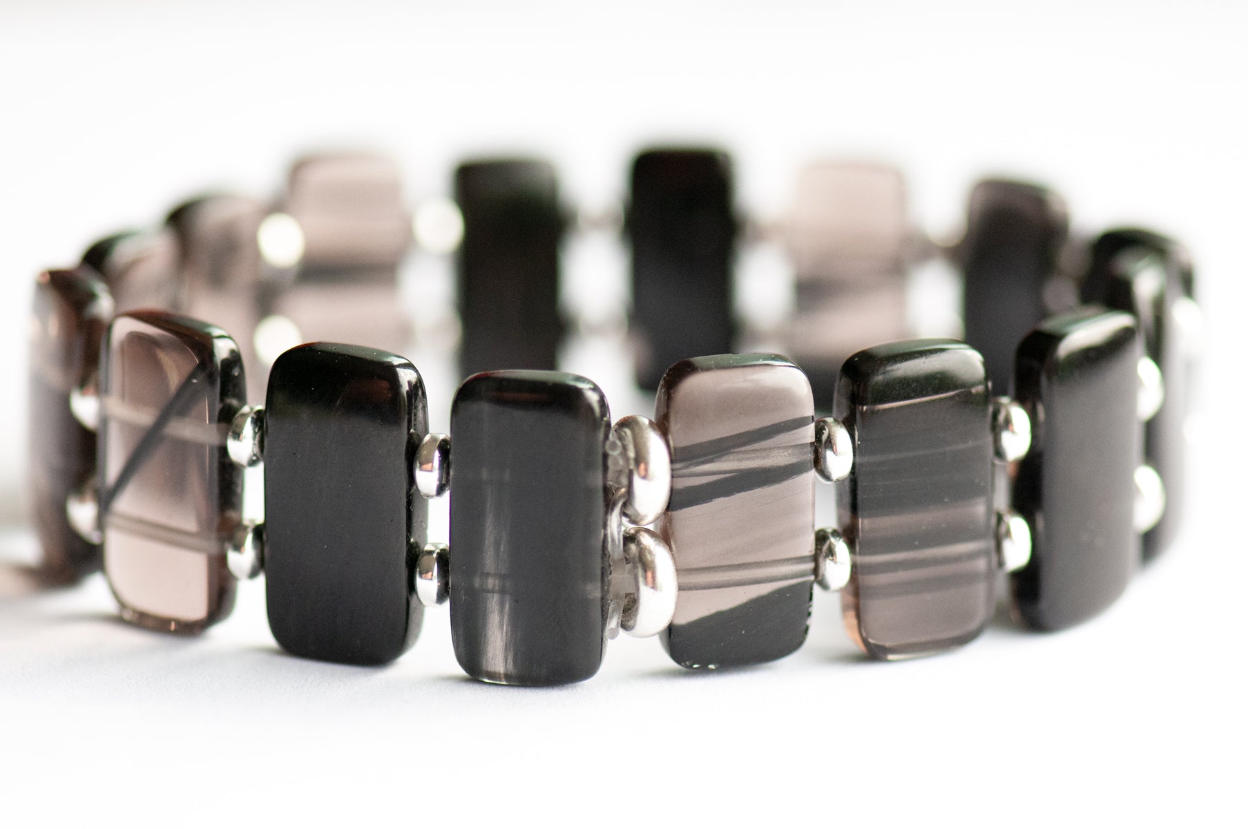 Ice Obsidian cuff bracelet — sleek black glass-like stone that reveals hidden streaks in the light. Handmade, ethically sourced, crafted in New Brunswick.