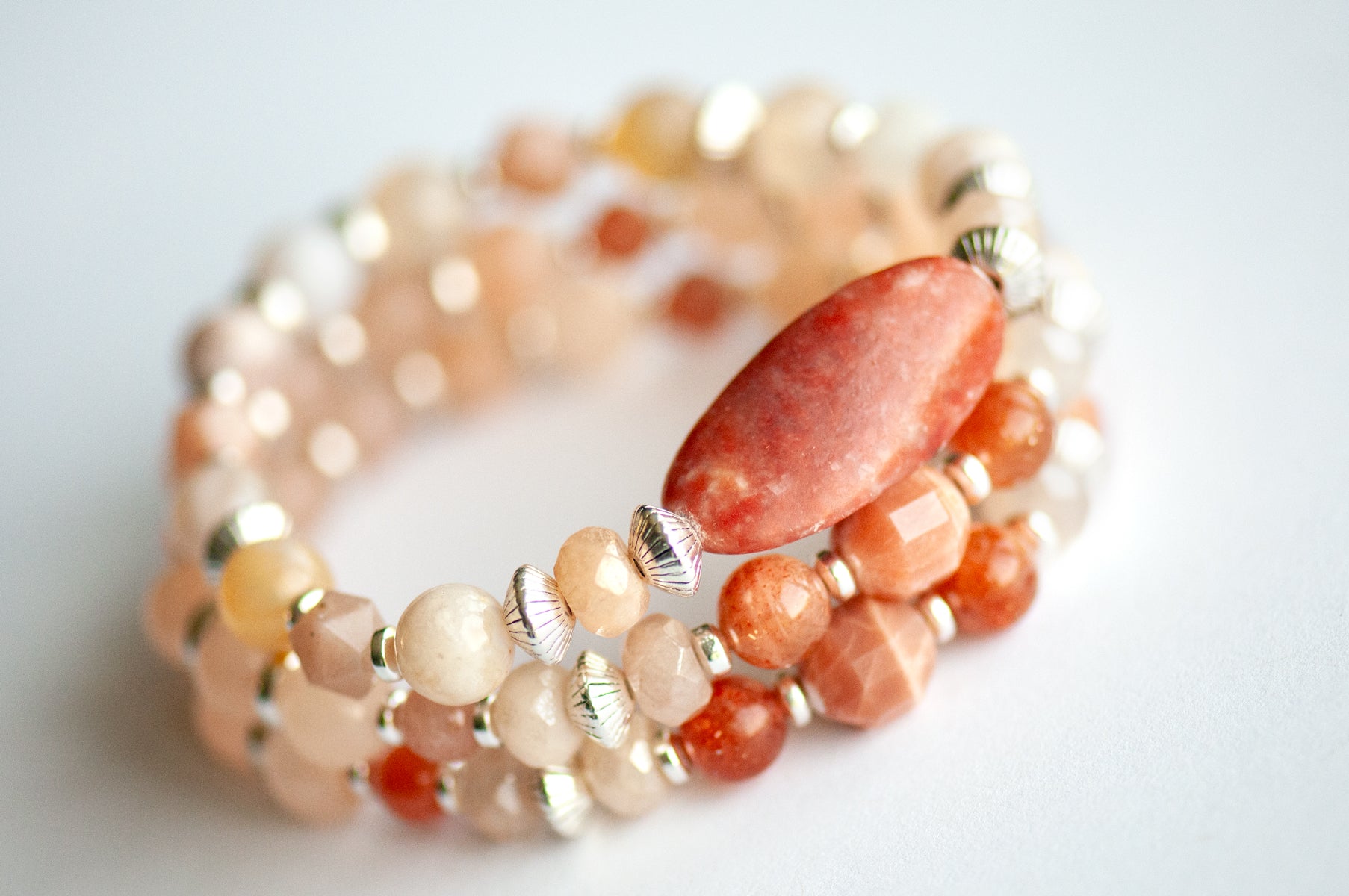 Chrysanthemum November birth flower bracelet set — side view, triple stack showing full layered effect in warm peachy golds and soft blush tones