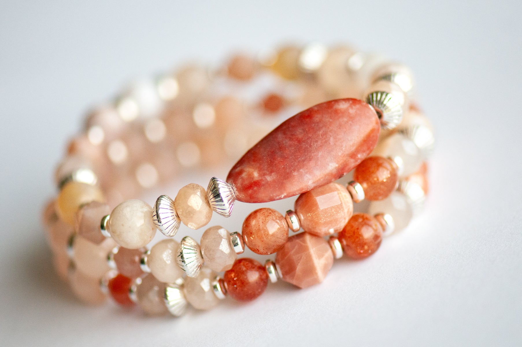 Chrysanthemum November birth flower bracelet set — side view, triple stack showing full layered effect in warm peachy golds and soft blush tones