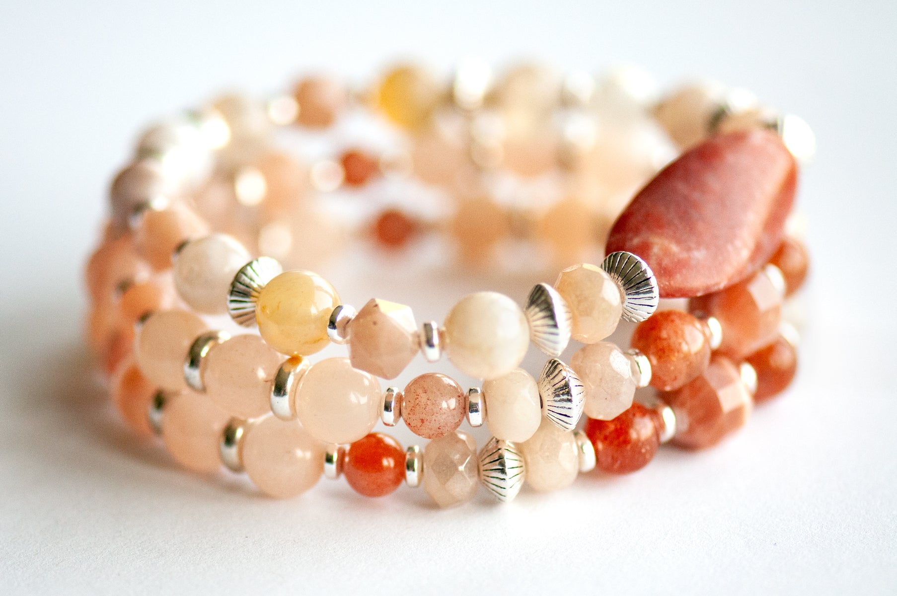 Chrysanthemum November birth flower bracelet set — side view, triple stack showing full layered effect in warm peachy golds and soft blush tones