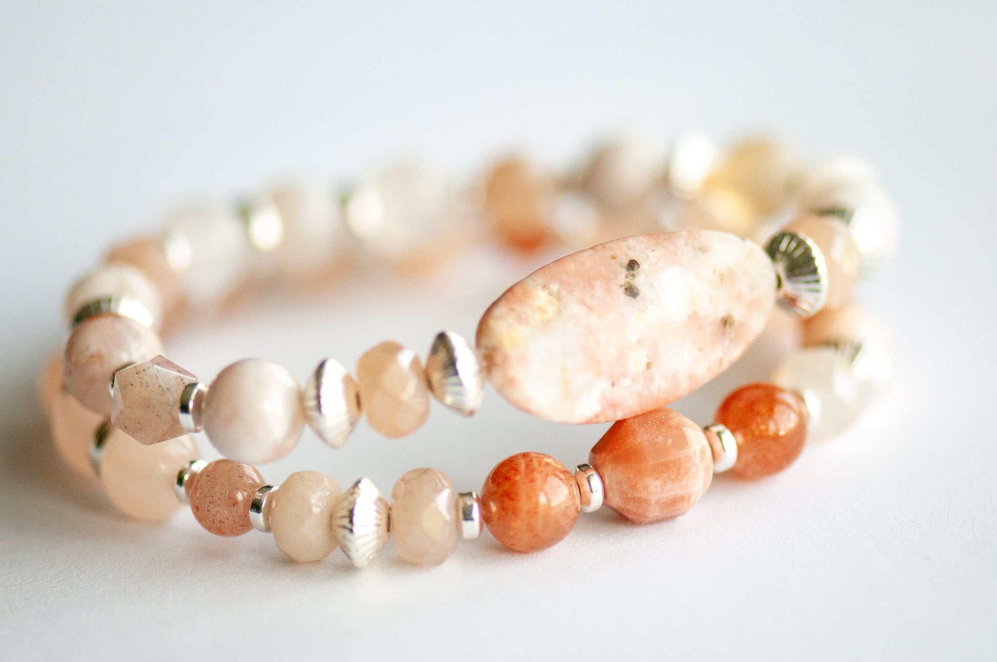 Chrysanthemum November birth flower bracelet set — side view, two bracelets showing peachy gold and blush gemstone rounds with silver hematite spacers