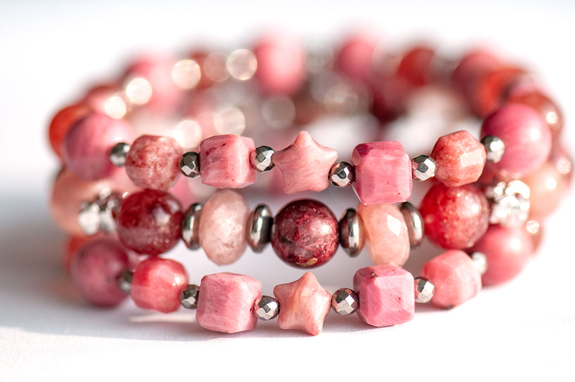 Carnation January birth flower bracelet set — front view, triple stack with two supporting bracelets featuring Pink Petrified Rhodonite carved stars, Rhodonite and Sakura Lodolite Quartz