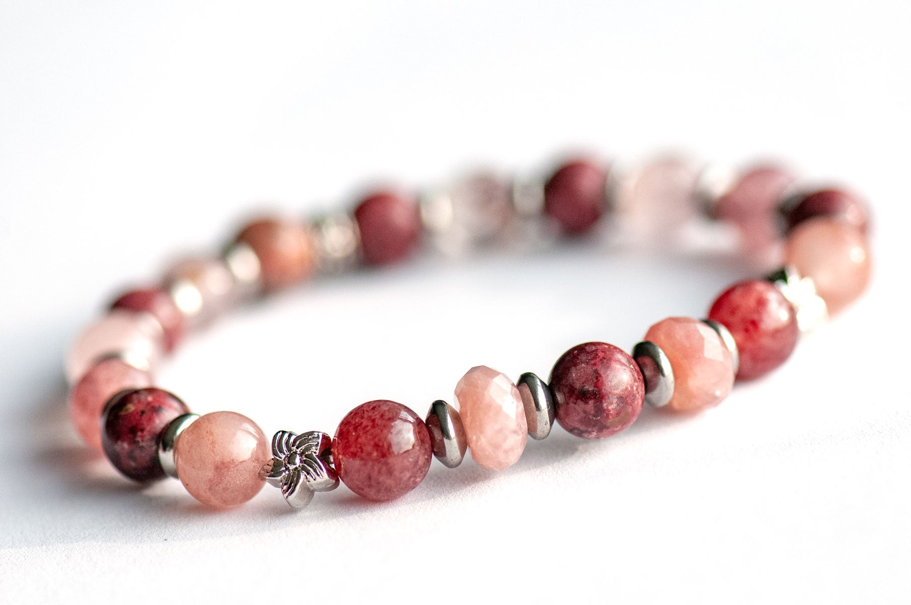 Carnation January birth flower focal bracelet — front view, deep wine Eudialyte rounds with AAA-Grade Red Strawberry Quartz, Berry Quartz and platinum flower bead accents