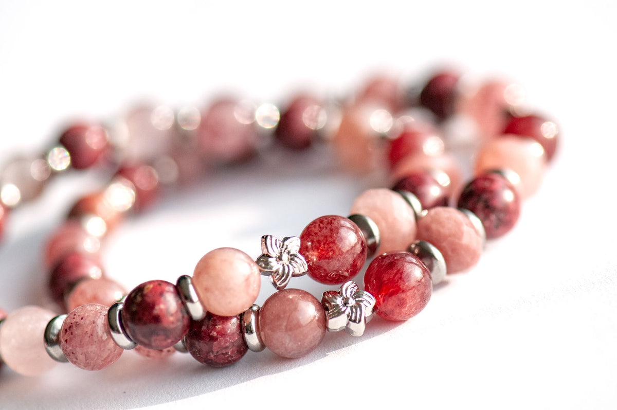 Carnation January birth flower focal bracelet — side view, showing depth and sparkle of Eudialyte and Strawberry Quartz rounds with platinum flower spacers