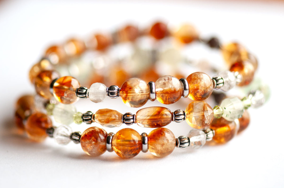 Daffodil March birth flower three-bracelet stack in whiskey-gold Citrine and spring green Prehnite, Peridot and Lodalite Quartz on a white background