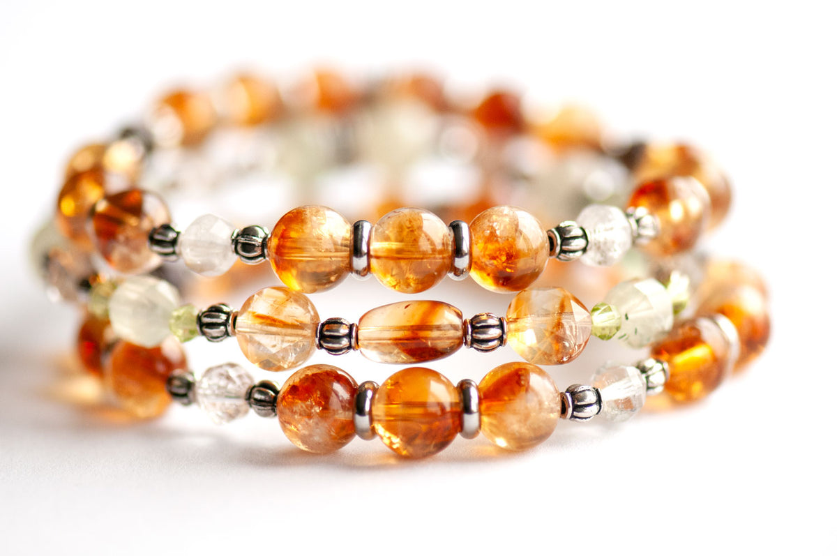 Daffodil March birth flower three-bracelet stack in whiskey-gold Citrine and spring green Prehnite, Peridot and Lodalite Quartz on a white background