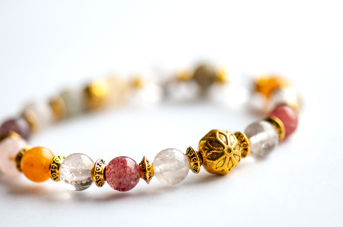 Fierce Multitude - Lodalite Quartz bracelet featuring a mix of clear, pink, and yellow stone beads interspersed with ornate antique golden-plated metal spacers and a central flower-shaped gold bead.