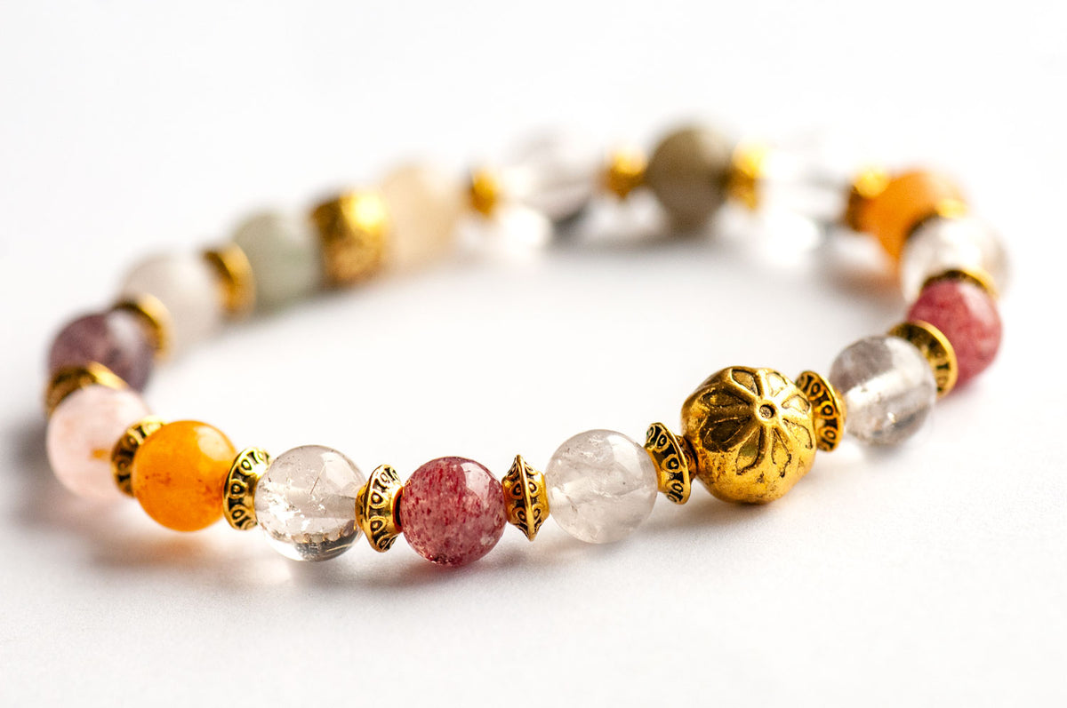 The Fierce Multitude - Lodalite Quartz Bracelet by Fierce Lynx Designs showcases multicolored round Lodalite Quartz stones accented with decorative antique golden-plated spacer beads, elegantly displayed on a white background.