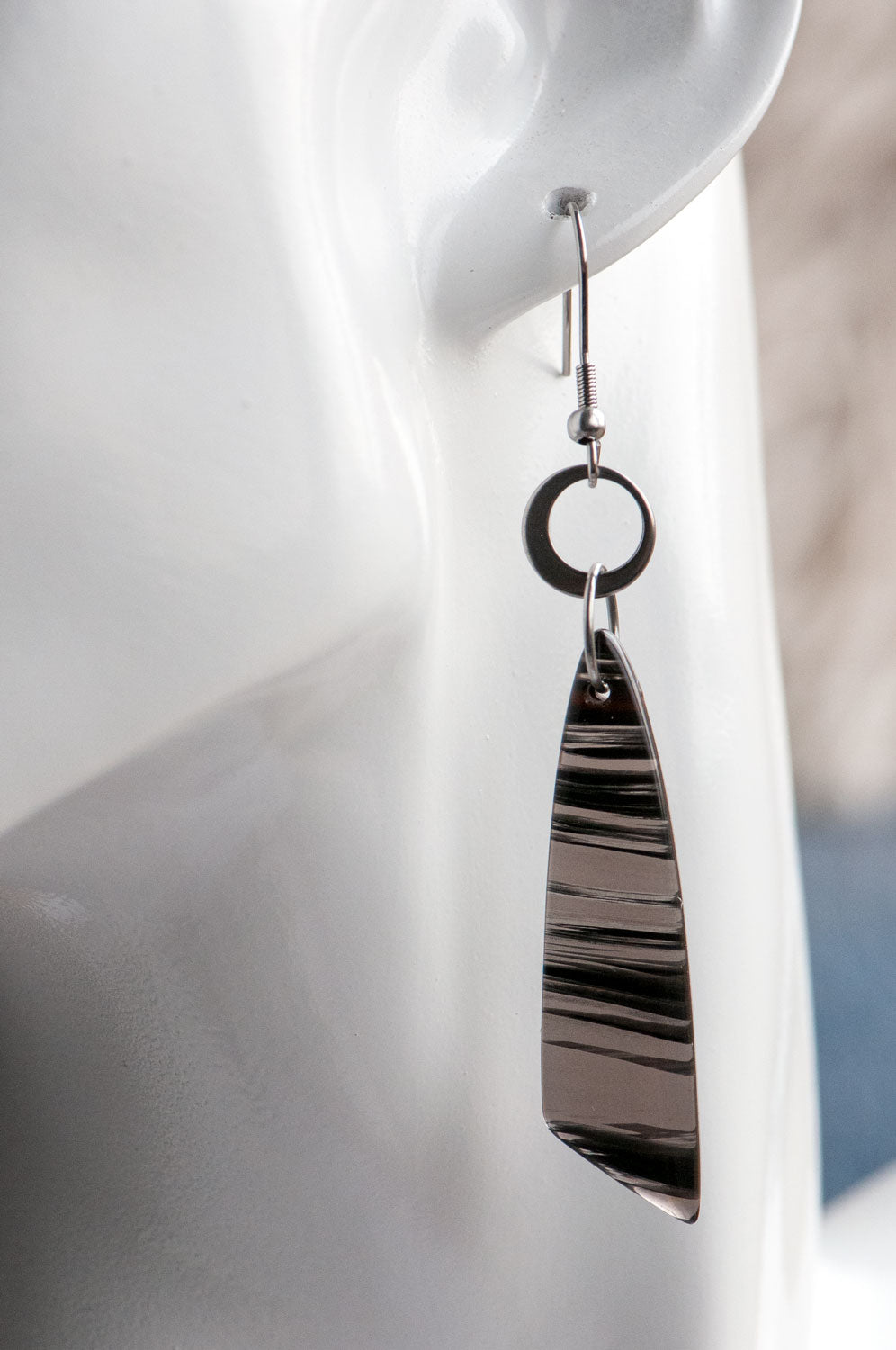 Ice Obsidian wing earrings worn on the ear, showing their just-under-9 cm length