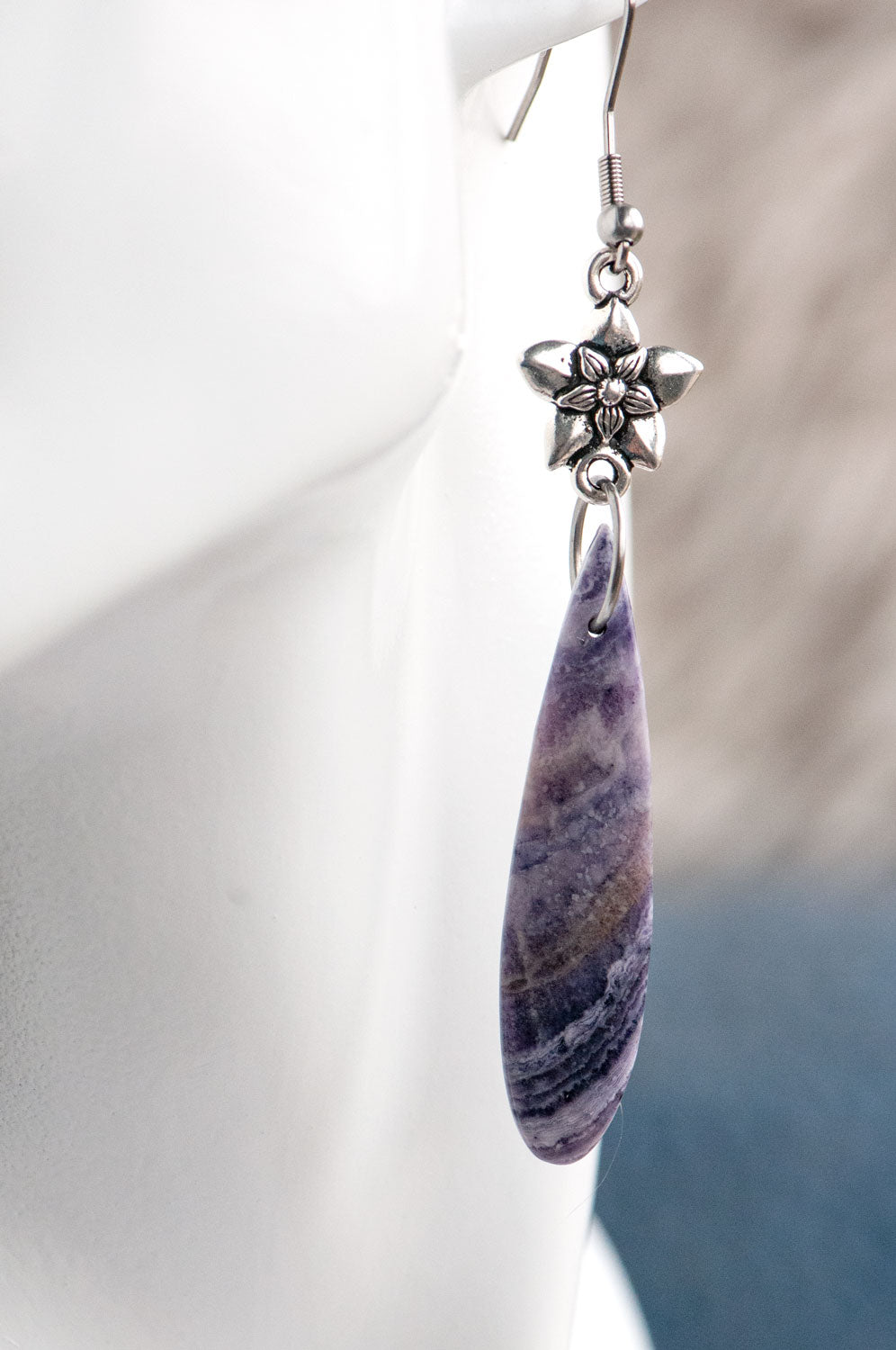 Purple opal teardrop earrings worn on the ear, showing the 8 cm total length