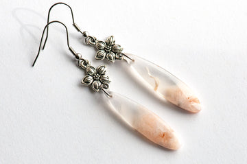 Close-up of a pale peach Cherry Blossom Agate teardrop with darker peach veining