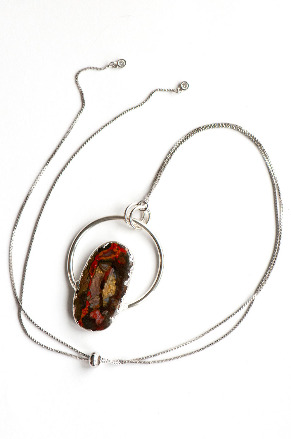 Silver box chain looped around a Moroccan Seam Agate pendant, with the adjustable slider bead and two cubic zirconia chain ends.