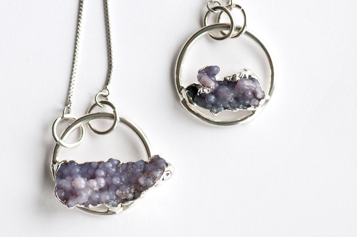 Two Purple Grape Agate hoop pendants, one larger and one smaller, with raw lavender clusters edged in electroformed silver.