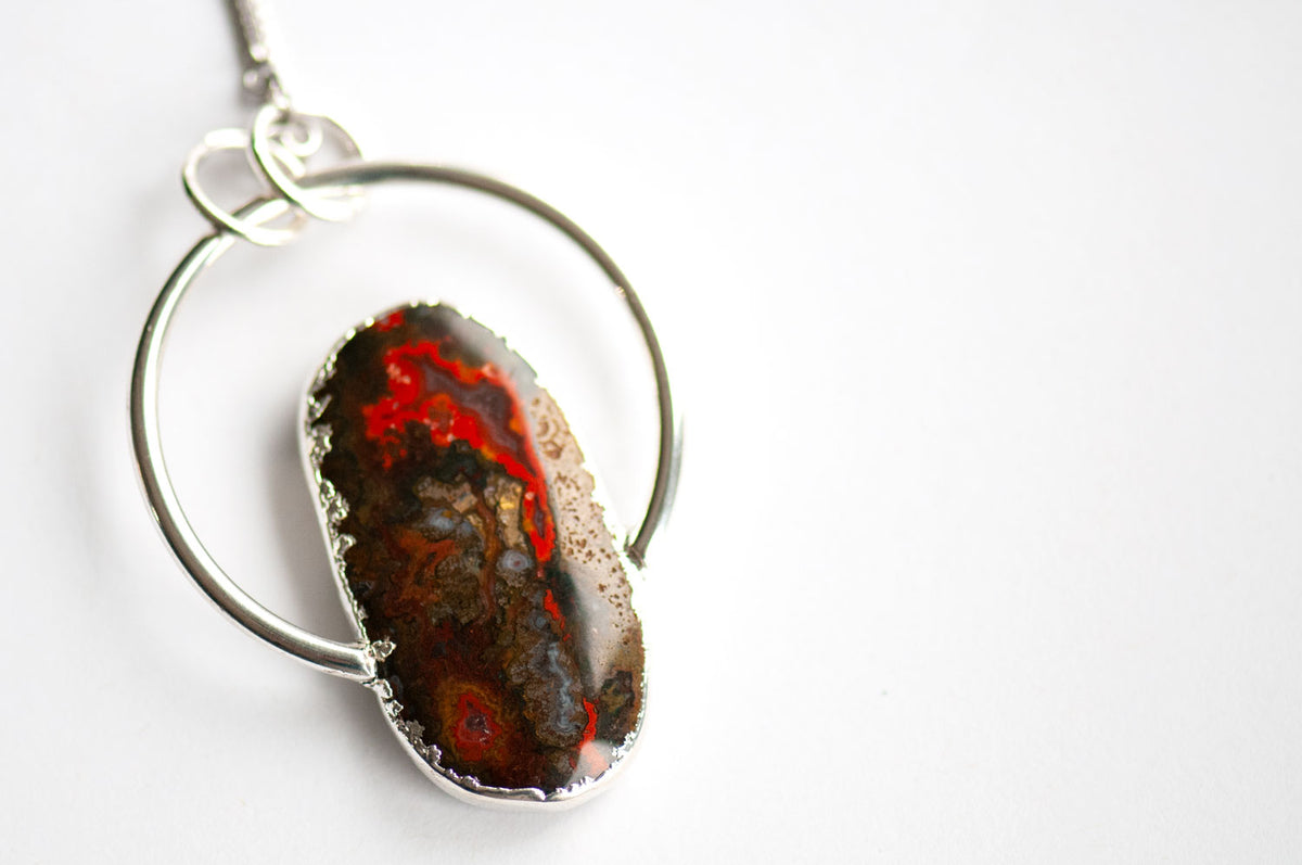 Reverse side of the Moroccan Seam Agate pendant, showing red banding and translucent grey agate along the silver-edged stone