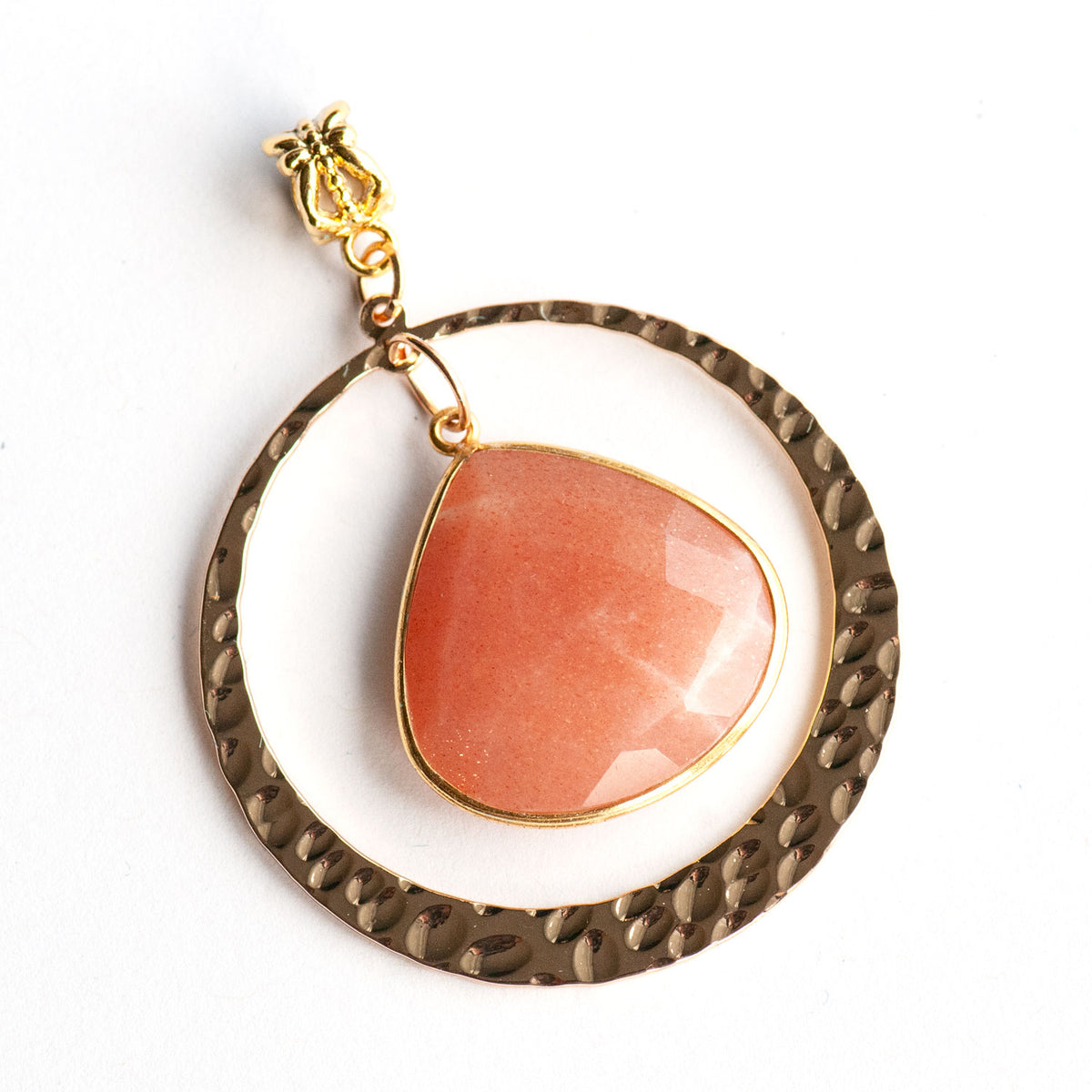 A pear-shaped peach moonstone pendant centered inside a hammered gold-tone circular frame, part of the Sunlit Lynx - Peach Moonstone Pendant with Customizable Chain by Fierce Lynx Designs.