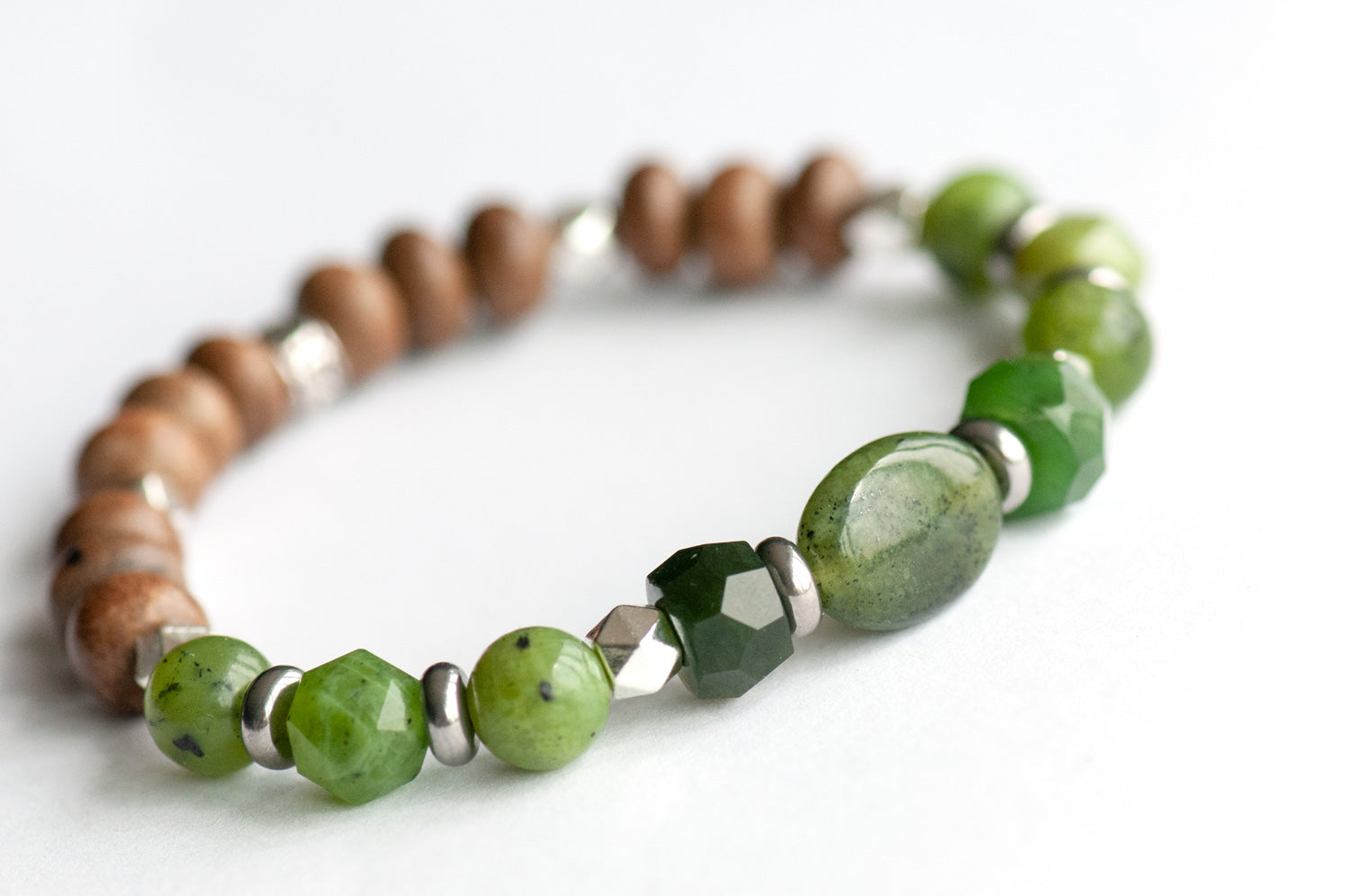 Feature bracelet from British Columbia Lynx Set – BC Jade oval focal with hand-cut rondelles, star-cut and round beads, grey wood accents, and silver spacers