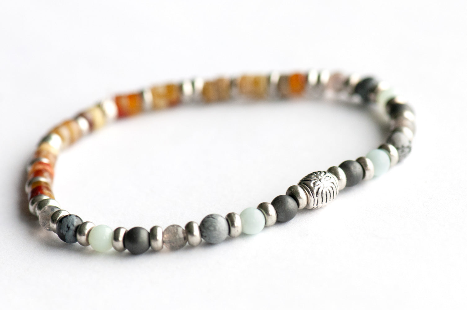 Supporting bracelet from Nunavut Lynx Set – 4mm stones with charm, including Snowflake Obsidian, Amazonite, Labradorite, Hematite, and Fire Serpentine heishis