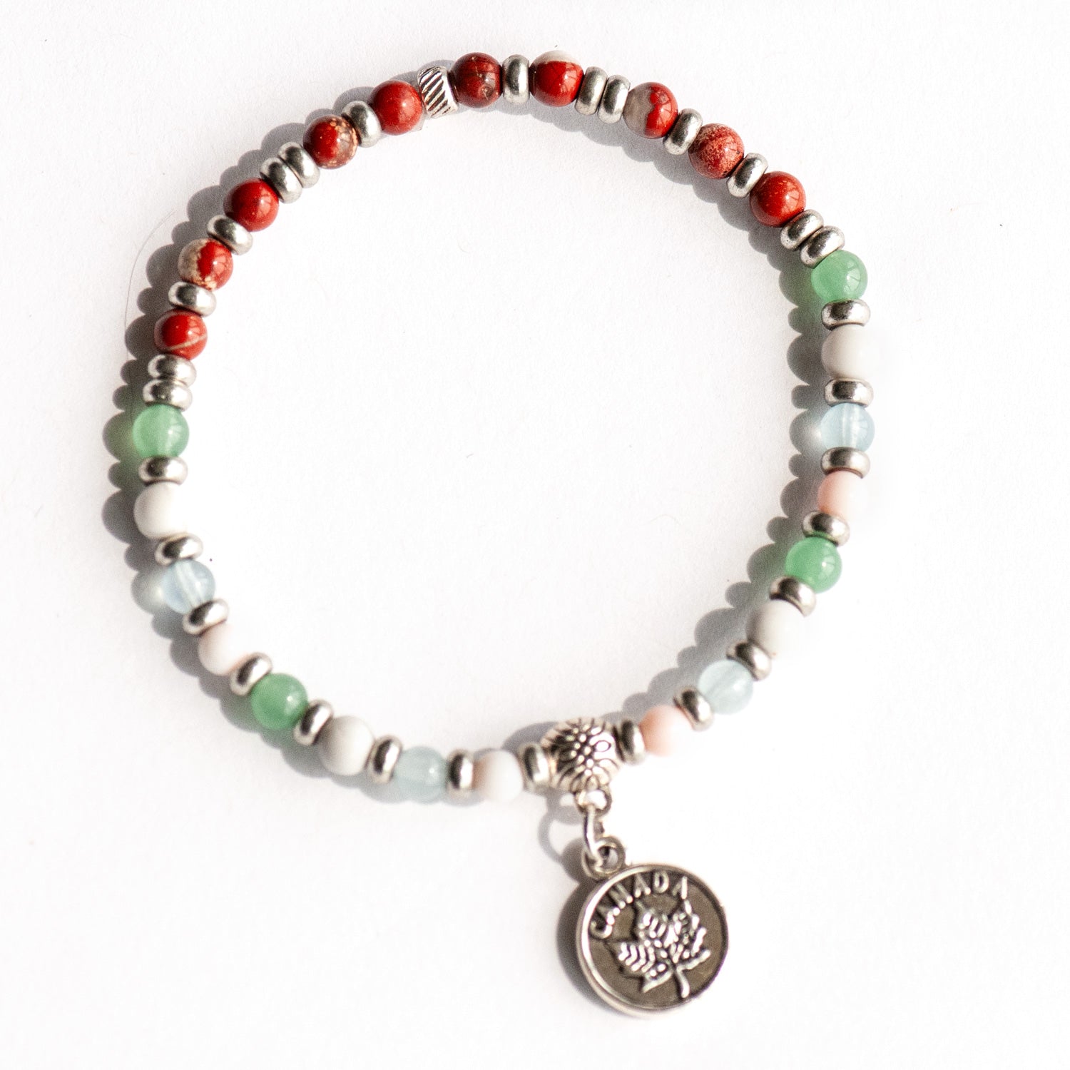 Supporting bracelet from Prince Edward Island Lynx Set – 4mm stones with charm, including Red Jasper, Green Aventurine, White Howlite, Aquamarine, and Queen Conch Shell