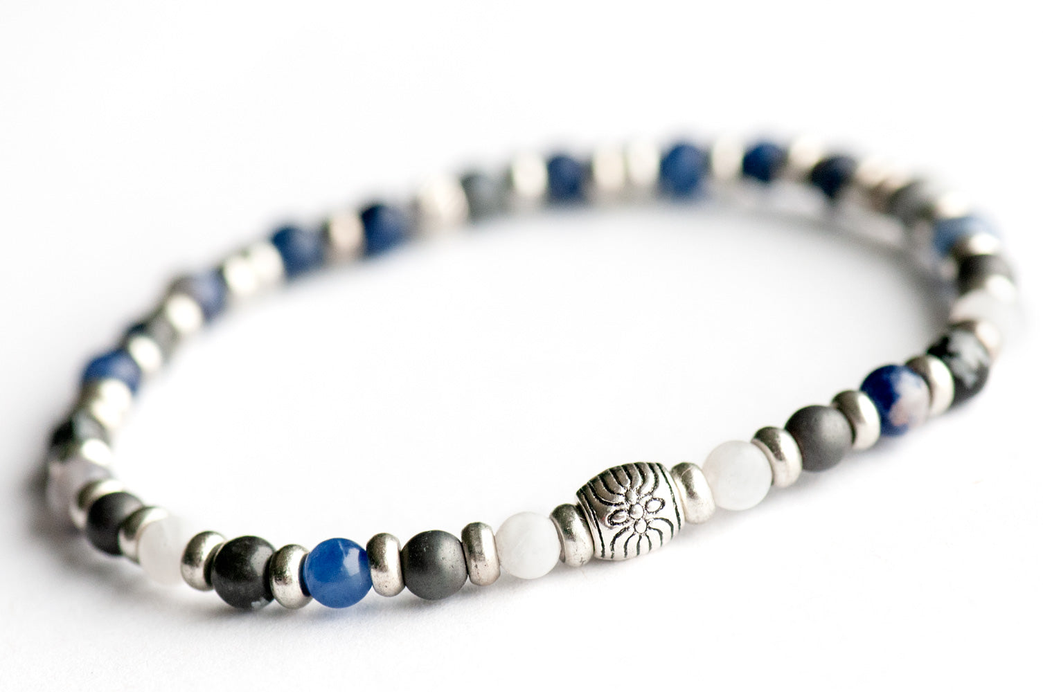 Supporting bracelet from Yukon Lynx Set – 4mm stones with charm, including Snowflake Obsidian, White Moonstone, Sodalite, Hematite, and Dumortierite