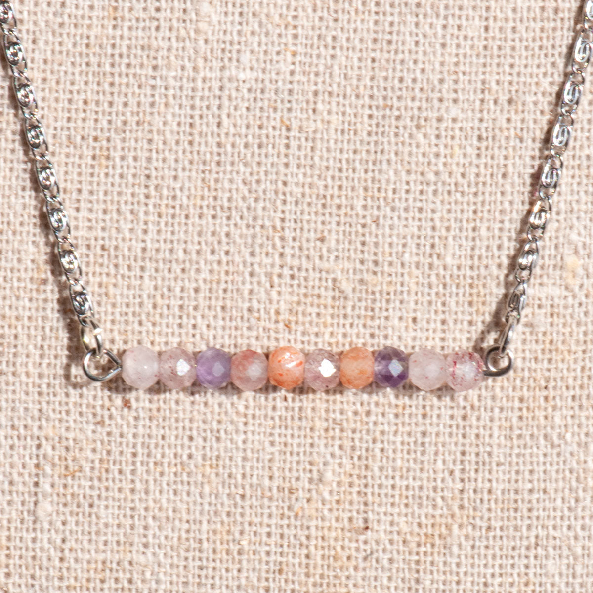 Handmade gemstone bar necklace with rainbow quartz in pink, peach, and purple