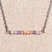 Handmade gemstone bar necklace with rainbow quartz in pink, peach, and purple